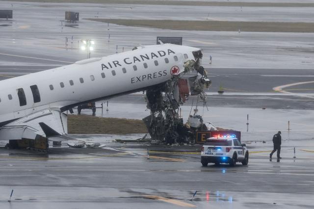 (FILES) An Air Canada Express CRJ-900 sits on the runway after colliding with a Port Authority fire truck at LaGuardia Airport in New York, on March 23, 2026. Two air traffic controllers left work early ahead of the deadly collision between an Air Canada jet and a fire truck at New York's LaGuardia Airport in March, The Wall Street Journal reported on August 27, 2026. (Photo by TIMOTHY A. CLARY / AFP)