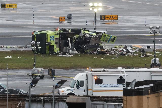 (FILES) A damaged Port Authority fire truck sits near the runway after colliding with an Air Canada Express CRJ-900 at LaGuardia Airport in New York, on March 23, 2026. Two air traffic controllers left work early ahead of the deadly collision between an Air Canada jet and a fire truck at New York's LaGuardia Airport in March, The Wall Street Journal reported on August 27, 2026. (Photo by TIMOTHY A. CLARY / AFP)