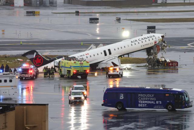 (FILES) An Air Canada Express CRJ-900 sits on the runway after colliding with a Port Authority fire truck at LaGuardia Airport in New York, on March 23, 2026. Two air traffic controllers left work early ahead of the deadly collision between an Air Canada jet and a fire truck at New York's LaGuardia Airport in March, The Wall Street Journal reported on August 27, 2026. (Photo by TIMOTHY A. CLARY / AFP)