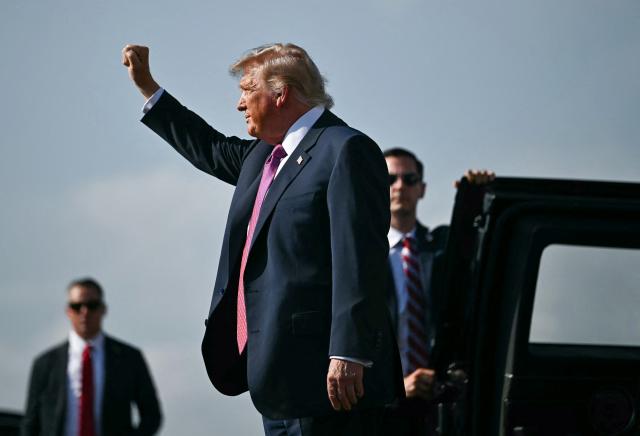 US President Donald Trump raises his fist before entering his limousine upon arrival at Ellington Airport in Houston, Texas, on August 27, 2026. Trump is in Houston to headline a Republican National Committee (RNC) fundraiser to boost Ken Paxton's US Senate campaign. (Photo by Kent NISHIMURA / AFP)