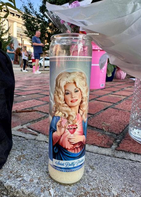 A "Saint Dolly Parton" candle stands at a makeshift memorial in Sieverville, Tennessee, on August 27, 2026. Parton, the country music star who rose from grinding poverty in Tennessee to become a rhinestone-studded cultural icon with hits like "Jolene" and "9 to 5," has died at 80, her family said on August 25, 2026. Parton was more than a singer, she wrote 3,000 songs, acted in major Hollywood films and donated millions of dollars to charities in her home state and beyond. (Photo by Michael Mathes / AFP)