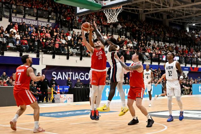 Chile's Felipe Haase (L) attempts a lay-up while being defended by US' Kevon Harris during the FIBA Basketball World Cup 2027 Americas qualifiers Group E match between Chile and the USA at the Centro de Deportes Colectivos stadium in Santiago on August 27, 2026. (Photo by RODRIGO ARANGUA / AFP)