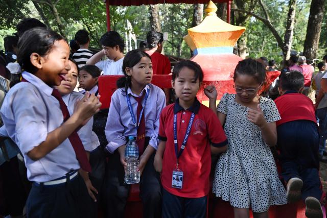 School children wait for a transit flight at Trishuli camp after being stranded by flash floods in Nepal's Nuwakot district on August 28, 2026. China and Nepal warned of fresh flooding risks, complicating rescuers' search for more than 1,400 people missing after a deadly deluge and landslides swept away entire villages along their remote Himalayan border. (Photo by Arun SANKAR / AFP)