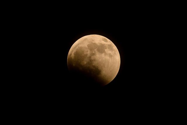 The moon enters Earth's umbra during a partial lunar eclipse over Panama City on August 27, 2026. (Photo by MARTIN BERNETTI / AFP)