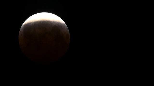 The moon enters the Earth's umbra during a partial lunar eclipse over Caracas on the early hours of August 28, 2026. (Photo by Juan BARRETO / AFP)