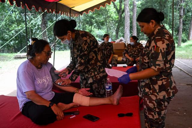 An injured woman rescued from a flash flood site receives medical care at Trishuli Army camp in Nepal's Nuwakot district on August 28, 2026. Devastating floods on the Nepal-Tibet border region have killed at least 469 people, Nepali police said on August 28, 48 hours after the disaster. (Photo by Arun SANKAR / AFP)