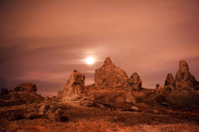 The Moon is seen over tufa spires during a partial lunar eclipse photographed from the Trona Pinnacles area near the town of Trona, California on August 27, 2026. (Photo by David Swanson / AFP)