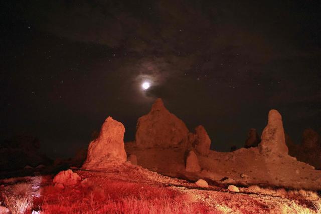 The Moon is seen over tufa spires during a partial lunar eclipse photographed from the Trona Pinnacles area near the town of Trona, California on August 27, 2026. (Photo by David Swanson / AFP)
