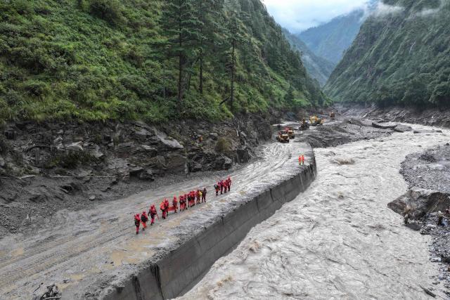 Fire and rescue personnel conduct search and rescue operations on a section of a road leading to Gyirong Port which was damaged after a mudslide two days earlier, in Gyirong County, in China’s western Tibet region on August 28, 2026. (Photo by CNS / AFP) / China OUT