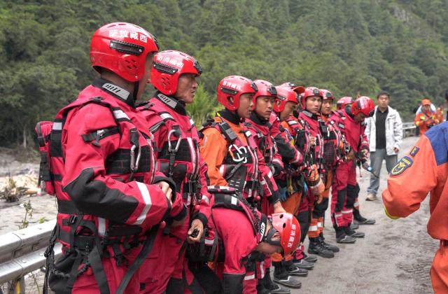 Fire and rescue personnel assemble before carrying out rescue operations on a section of a road leading to Gyirong Port which was damaged after a mudslide two days earlier, in Gyirong County, in China’s western Tibet region on August 28, 2026. (Photo by CNS / AFP) / China OUT