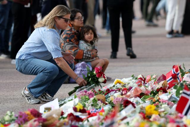 A woman lays a flower to pay tribute to King Harald V of Norway who passed away, at the Royal Palace square in Oslo on August 28, 2026. King Harald V of Norway, who died on August 28, 2026 aged 89, remained a unifying figure in his country until the very end, a pillar of stability amid a string of family scandals that tarnished the final years of his reign. (Photo by Odd ANDERSEN / AFP)