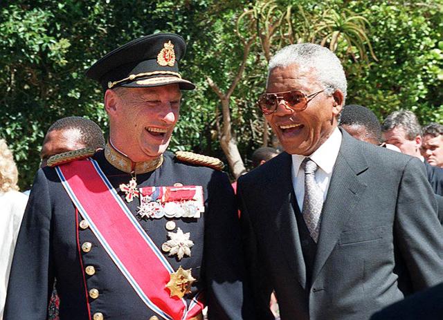 (FILES) King Harald of Norway (L) and President Nelson Mandela laugh as they stroll through the gardens of Tuynhuis, Cape Town on February 23, 1998. Norway's King Harald V, Europe's oldest reigning monarch, died on August 28,2026 at the age of 89, the royal palace announced. (Photo by ANNA ZIEMINSKI / AFP)
