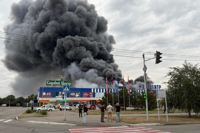 Ukrainian rescue personnel work to extinguish a fire in a damaged shopping mall following an air attack in Zaporizhzhia on August 28, 2026, amid the Russian invasion of Ukraine. (Photo by Darya NAZAROVA / AFP)