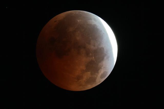 A picture taken from Madrid on August 28, 2026 shows a maximum portion of the Moon within the Earth's umbra during a partial lunar eclipse. (Photo by Thomas COEX / AFP)
