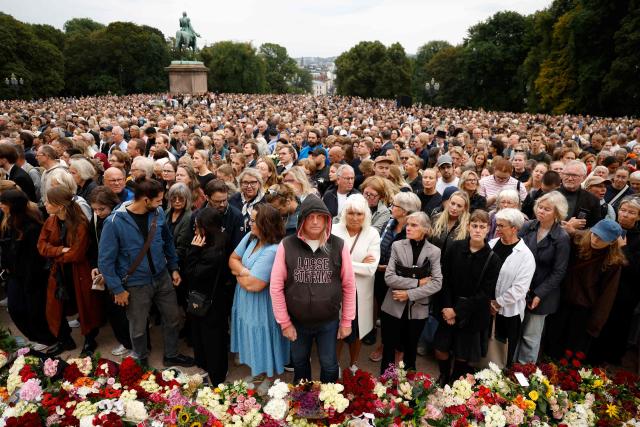 Mourners stand and listen to a gun salute outside the royal palace as they pay tribute after King Harald V of Norway passed away in Oslo, Norway on August 28, 2026. King Harald V of Norway, who died on August 28, 2026 aged 89, remained a unifying figure in his country until the very end, a pillar of stability amid a string of family scandals that tarnished the final years of his reign. (Photo by Odd ANDERSEN / AFP)