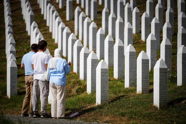 Visitors stand at the memorial cemetery in the village of Potocari, following the death of former Bosnian Serb military chief Ratko Mladic near the eastern Bosnian town of Srebrenica, on August 28, 2026. Mladic died in a prison hospital in The Hague aged 84 after suffering several strokes. He was priorly convicted of genocide, crimes against humanity and war crimes, was known as the "Butcher of Bosnia" for his role in the 1995 Srebrenica massacre, Europe's worst atrocity since World War II. (Photo by Nidal Saljic / AFP)