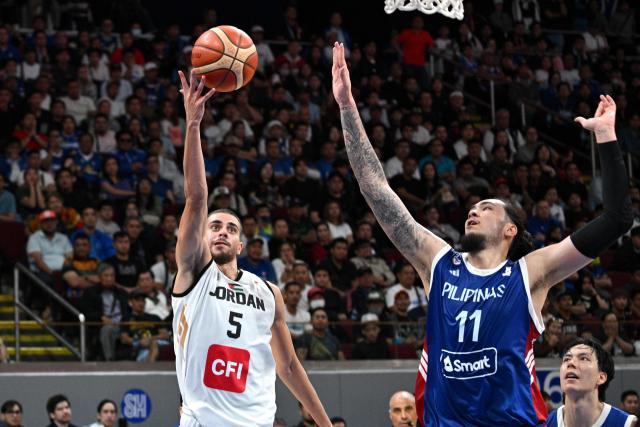 Jordan's Freddy Ibrahim (L) lays up against Philippines' Kai Sotto during their 2027 FIBA Basketball World Cup Asian qualifier group E match at the Mall of Asia Arena in Pasay city, Metro Manila on August 28, 2026. (Photo by Ted ALJIBE / AFP)