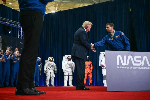 NASA astronaut and commander Reid Wiseman (R) shakes hands with US President Donald Trump after Trump presented him with a Congressional Space Medal of Honor during a ceremony at NASA Lyndon B. Johnson Space Center in Houston, Texas, on August 28, 2026. The Artemis II crew are being honored with the Congressional Space Medal of Honor for their historic mission around the Moon. (Photo by Kent NISHIMURA / AFP)