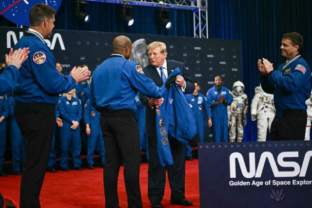 NASA astronaut and pilot Victor Glover hands US President Donald Trump a jacket after Trump presented the Artemis II crew members with the Congressional Space Medal of Honor at NASA Lyndon B. Johnson Space Center in Houston, Texas, on August 28, 2026. The Artemis II astronauts crew are honored with the Congressional Space Medal of Honor for their historic mission around the Moon. (Photo by Kent NISHIMURA / AFP)