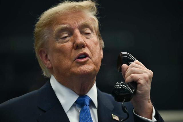 US President Donald Trump talks on the phone with crew members of the International Space Station (ISS) at Mission Control Center at NASA Lyndon B. Johnson Space Center in Houston, Texas, on August 28, 2026. During his visit, President Trump honored the Artemis II crew with the Congressional Space Medal of Honor for their historic mission around the Moon and signed an executive order that aims to create a US Space Academy. (Photo by Kent NISHIMURA / AFP)