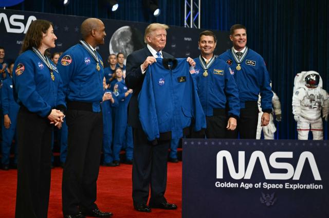 US President Donald Trump holds up a jacket given to him by the Artemis II crew members after presenting them with the Congressional Space Medal of Honor at NASA Lyndon B. Johnson Space Center in Houston, Texas, on August 28, 2026. The Artemis II astronauts crew are honored with the Congressional Space Medal of Honor for their historic mission around the Moon. (Photo by Kent NISHIMURA / AFP)