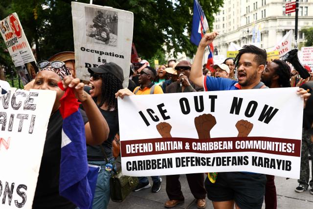 People hold signs during a protest against the termination of Temporary Protected Status (TPS) for the Haitian community and to end mass deportations, at Foley Square in New York City on August 28, 2026. The Supreme Court said in late June 2026 that the Trump administration is allowed to end Temporary Protected Status (TPS) for Haitians and some 6,000 Syrians without judicial review, although the impact of the decision could apply to migrants from many other backgrounds. An estimated 350,000 Haitians live in the United States under the program, with many working in healthcare and construction. (Photo by CHARLY TRIBALLEAU / AFP)