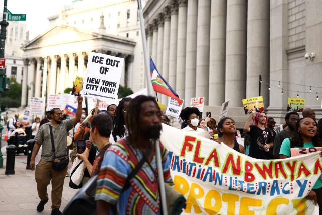 People hold signs during a protest against the termination of Temporary Protected Status (TPS) for the Haitian community and to end mass deportations, at Foley Square in New York City on August 28, 2026. The Supreme Court said in late June 2026 that the Trump administration is allowed to end Temporary Protected Status (TPS) for Haitians and some 6,000 Syrians without judicial review, although the impact of the decision could apply to migrants from many other backgrounds. An estimated 350,000 Haitians live in the United States under the program, with many working in healthcare and construction. (Photo by CHARLY TRIBALLEAU / AFP)