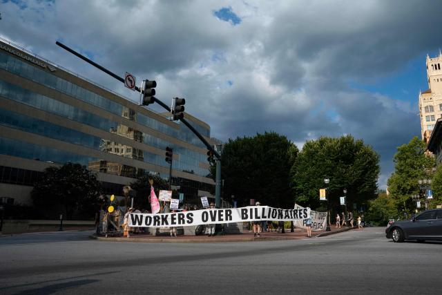 People hold a banner reading "workers over billionaires" as they protest ahead of the G20 Finance ministers and central bank governors meeting on August 28, 2026, in Asheville, North Carolina. Asheville is hosting the G20 meetings from August 29 to September 1. (Photo by Allison Joyce / AFP)