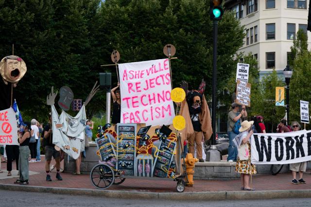 People hold banners and signs as they protest ahead of the G20 Finance ministers and central bank governors meeting on August 28, 2026, in Asheville, North Carolina. Asheville is hosting the G20 meetings from August 29 to September 1. (Photo by Allison Joyce / AFP)