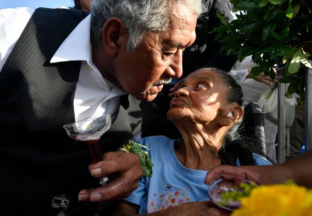 A groom and a bride exchange a kiss in a mass wedding as part of the Family Month celebration in front of the Church of Santa Maria de los Dolores in Tegucigalpa on August 28, 2026. (Photo by Orlando SIERRA / AFP)