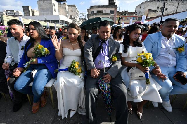 Several couples get married in a mass wedding as part of the Family Month celebration in front of the Church of Santa Maria de los Dolores in Tegucigalpa on August 28, 2026. (Photo by Orlando SIERRA / AFP)