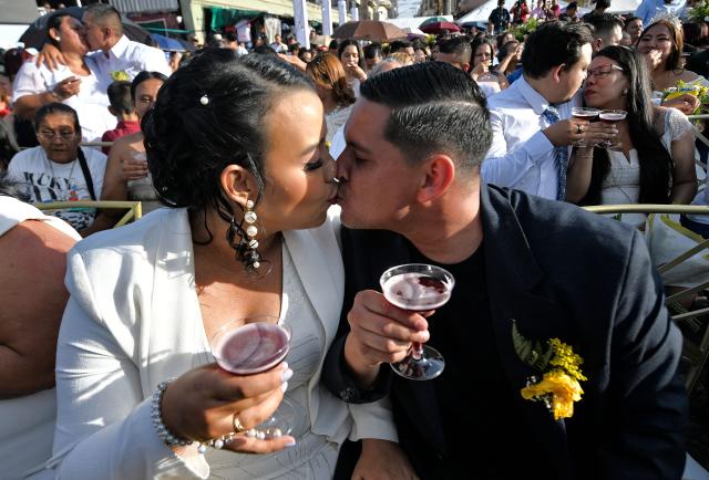 A bride and groom exchange a kiss in a mass wedding as part of the Family Month celebration in front of the Church of Santa Maria de los Dolores in Tegucigalpa on August 28, 2026. (Photo by Orlando SIERRA / AFP)