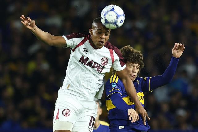 Lanus' Colombian forward #19 Yoshan Valois (L) heads the ball past Boca Juniors' defender #42 Facundo Herrera (R) during the Argentine Professional League 2026 Clausura tournament football match between Boca Juniors and Lanus, at La Bombonera stadium in Buenos Aires on August 28, 2026. (Photo by Alejandro PAGNI / AFP)