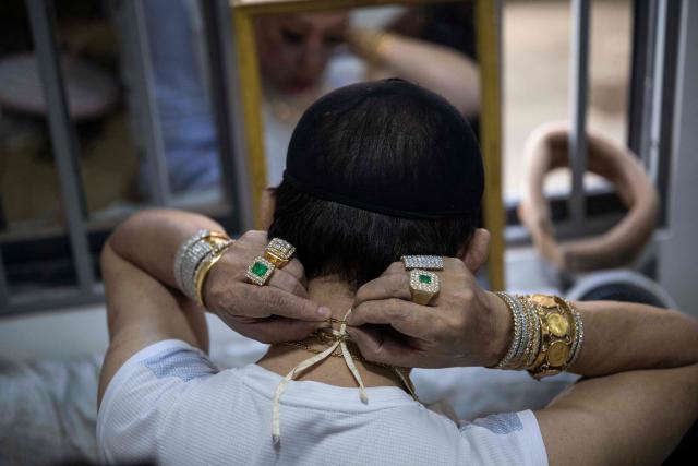 A spirit medium, known locally as a "Nat-kadaw," prepares before performing a ritual dance during the annual Taungbyone Spirit Festival in Madaya township, Mandalay region on August 26, 2026. As monsoon rains pound the heartlands of war-fractured Myanmar, "spirit consorts" gather to renew their vows with a pantheon of gods hailed for their powers to protect and destroy. (Photo by SAI AUNG MAIN / AFP) / TO GO WITH AFP STORY: Myanmar-religion-festival-conflict, FOCUS