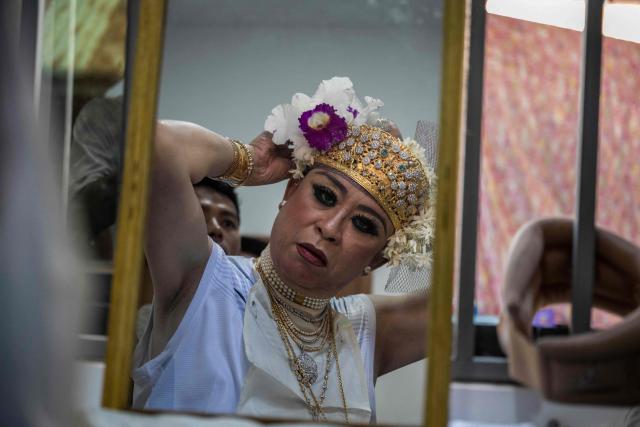 A spirit medium, known locally as a "Nat-kadaw," prepares before performing a ritual dance during the annual Taungbyone Spirit Festival in Madaya township, Mandalay region on August 26, 2026. As monsoon rains pound the heartlands of war-fractured Myanmar, "spirit consorts" gather to renew their vows with a pantheon of gods hailed for their powers to protect and destroy. (Photo by SAI AUNG MAIN / AFP) / TO GO WITH AFP STORY: Myanmar-religion-festival-conflict, FOCUS