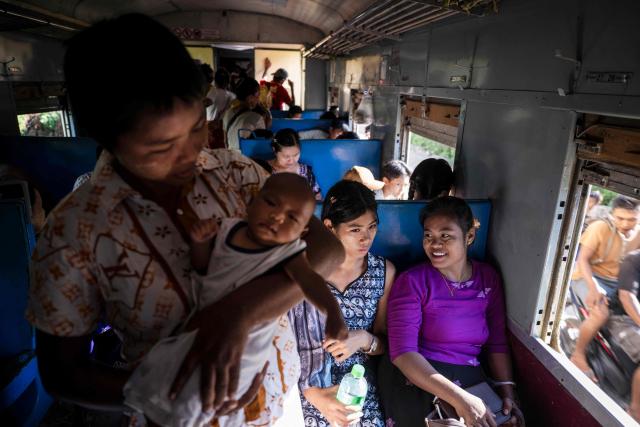 People travel on a commuter train between Mandalay and Taungbyone for the annual Taungbyone Spirit Festival in Madaya township, Mandalay region on August 26, 2026. As monsoon rains pound the heartlands of war-fractured Myanmar, "spirit consorts" gather to renew their vows with a pantheon of gods hailed for their powers to protect and destroy. (Photo by SAI AUNG MAIN / AFP) / TO GO WITH AFP STORY: Myanmar-religion-festival-conflict, FOCUS