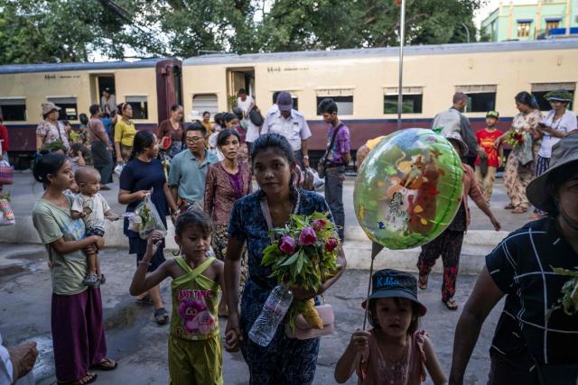 People walk along a platform next to a train packed with passengers arriving at the station after they celebrated the annual Taungbyone Spirit (Nat) Festival in Mandalay on August 26, 2026. As monsoon rains pound the heartlands of war-fractured Myanmar, "spirit consorts" gather to renew their vows with a pantheon of gods hailed for their powers to protect and destroy. (Photo by SAI AUNG MAIN / AFP) / TO GO WITH AFP STORY: Myanmar-religion-festival-conflict, FOCUS