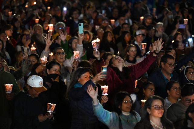 People hold candles during a vigil in honor of the earthquake victims at Bolivar square in Bogota, on August 28, 2026. (Photo by Raul ARBOLEDA / AFP)