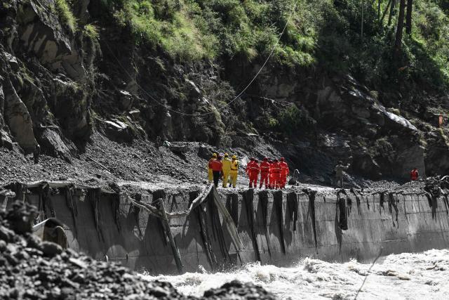 Fire and rescue personnel conduct search and rescue operations on a section of road leading to Gyirong Port which was damaged after a mudslide two days earlier, in Gyirong County, in China’s western Tibet region on August 28, 2026. (Photo by CNS / AFP) / China OUT