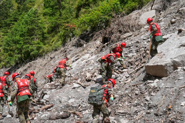 Paramilitary police conduct search and rescue operations on a hillside 2 kilometers from Gyirong Port which was damaged after a mudslide two days earlier, in Gyirong County, in China’s western Tibet region on August 28, 2026. (Photo by CNS / AFP) / China OUT