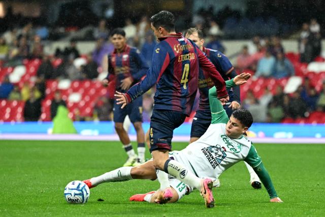 Leon's Colombian midfielder #13 Daniel Arcila slides for the ball past Atlante's defender #04 Eduardo Tercero during the Liga MX Apertura tournament football match between Atlante and Leon at the Ciudad de los Deportes stadium in Mexico City, on August 28, 2026. (Photo by YURI CORTEZ / AFP)