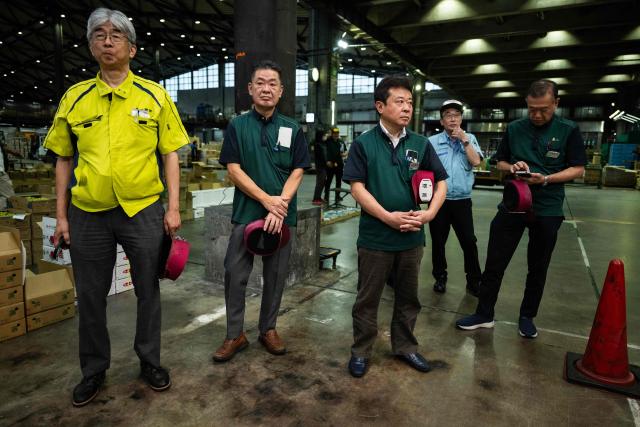 Wholesale market employees and buyers wait for the start of a promotional event for Tottori-grown Nijisseiki, or "20th Century" pears, ahead of the season's first auction at Ota Market in Tokyo on August 29, 2026. The auction took place two days after a record 600,000 yen (USD 3,748) was paid for a 10-kilogram box of the pear variety at the season's opening auction in Osaka. First introduced in 1904 and now a signature product of Tottori Prefecture, the variety is among Japan's best-known pears. (Photo by Andrew CABALLERO-REYNOLDS / AFP)