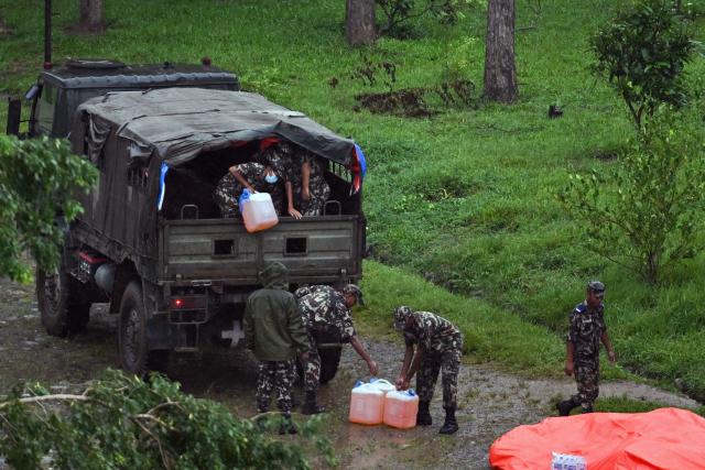 Nepali soldiers unload fuel cans from a truck to be flown in by helicopter as part of relief supplies at Trishuli in Nepal's Nuwakot district on August 29, 2026, after flash floods and landslides hit the Nepal-Tibet border. Rescuers in Nepal and China were still battling August 29 to locate thousands of people missing days after a deadly, tsunami-like wall of water and debris swept through the Himalayan region, engulfing villages. (Photo by Arun SANKAR / AFP)