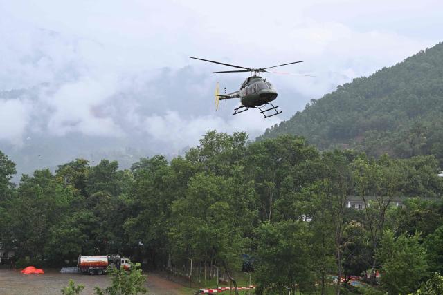 A Nepali army helicopter flies relief sorties from Trishuli in Nepal's Nuwakot district on August 29, 2026, after flash floods and landslides hit the Nepal-Tibet border. Rescuers in Nepal and China were still battling August 29 to locate thousands of people missing days after a deadly, tsunami-like wall of water and debris swept through the Himalayan region, engulfing villages. (Photo by Arun SANKAR / AFP)