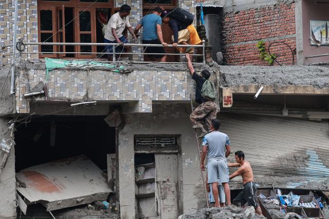 Residents climb up to their house to search for belongings at the Dhunge Bazaar in Nepal's Nuwakot district on August 29, 2026 after flash floods and landslides hit the Nepal-Tibet border. Rescuers in Nepal and China were still battling August 29 to locate thousands of people missing days after a deadly, tsunami-like wall of water and debris swept through the Himalayan region, engulfing villages. The number of missing soared past 2,400 on August 28 as emergency teams said they had recovered 623 bodies -- with some of the dead possibly swept downstream as far away as India. (Photo by PRABIN RANABHAT / AFP)