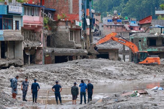 Workers use excavators to clear the mud at the Dhunge Bazaar in Nepal's Nuwakot district on August 29, 2026 after flash floods and landslides hit the Nepal-Tibet border. Rescuers in Nepal and China were still battling August 29 to locate thousands of people missing days after a deadly, tsunami-like wall of water and debris swept through the Himalayan region, engulfing villages. The number of missing soared past 2,400 on August 28 as emergency teams said they had recovered 623 bodies -- with some of the dead possibly swept downstream as far away as India. (Photo by PRABIN RANABHAT / AFP)