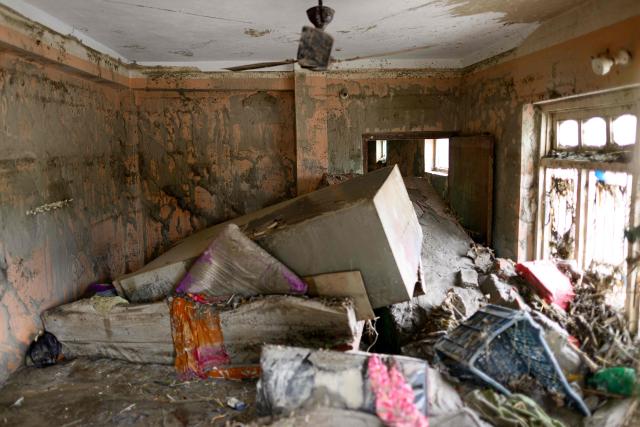 A room is seen heavily covered in mud inside a house in the aftermath of flash floods at Devighat in Nepal's Nuwakot district on August 29, 2026. Rescuers in Nepal and China were still battling on August 29 to locate thousands of people missing days after a deadly, tsunami-like wall of water and debris swept through the Himalayan region, engulfing villages. Nearly 3,000 people were still missing on August 29 and 633 confirmed dead after flash floods and landslides hit the Nepal-Tibet border. (Photo by Manan VATSYAYANA / AFP)