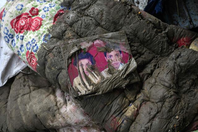 A family photograph lies on a mattress covered in mud outside a house in the aftermath of flash floods at Devighat in Nepal's Nuwakot district on August 29, 2026. Rescuers in Nepal and China were still battling on August 29 to locate thousands of people missing days after a deadly, tsunami-like wall of water and debris swept through the Himalayan region, engulfing villages. Nearly 3,000 people were still missing on August 29 and 633 confirmed dead after flash floods and landslides hit the Nepal-Tibet border. (Photo by MANAN VATSYAYANA / AFP)