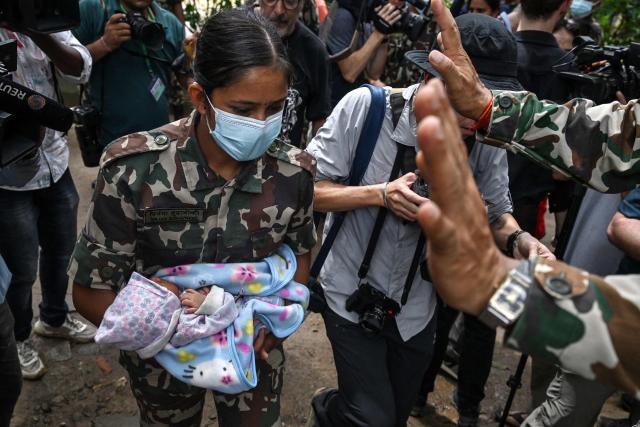 An Army personnel carries a rescued infant in the aftermath of flash floods at Trishuli camp in Nepal's Nuwakot district on August 29, 2026. Nearly 3,000 people were still missing on August 29 and 633 confirmed dead after flash floods and landslides hit the Nepal-Tibet border. (Photo by Arun SANKAR / AFP)