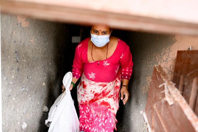 A woman salvages her belongings from her house heavily covered in mud in the aftermath of flash floods at Devighat in Nepal's Nuwakot district on August 29, 2026. Nearly 3,000 people were still missing on August 29 and 633 confirmed dead after flash floods and landslides hit the Nepal-Tibet border. (Photo by Manan VATSYAYANA / AFP)